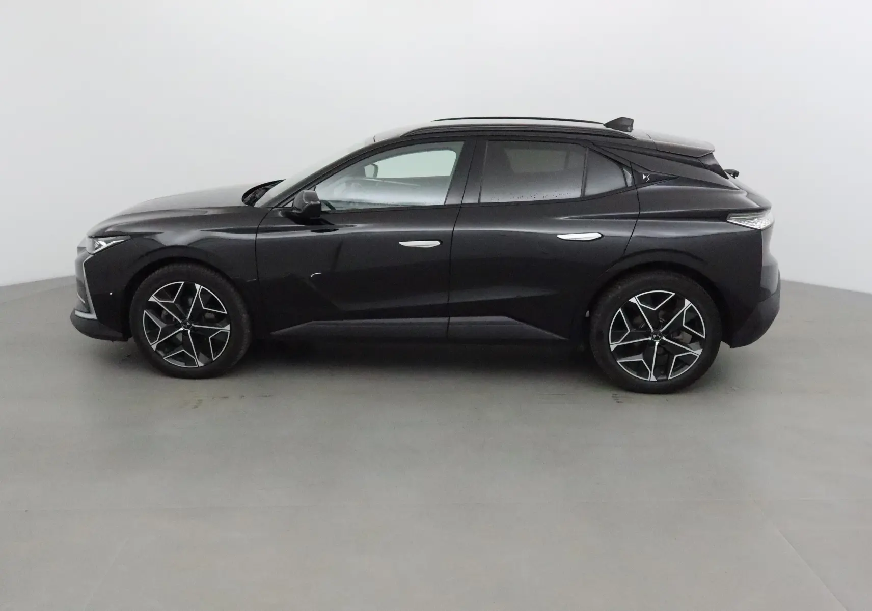 Profil côté gauche d'une DS4 noire 2022 avec jantes alliage 19 pouces et lignes sculptées élégantes.