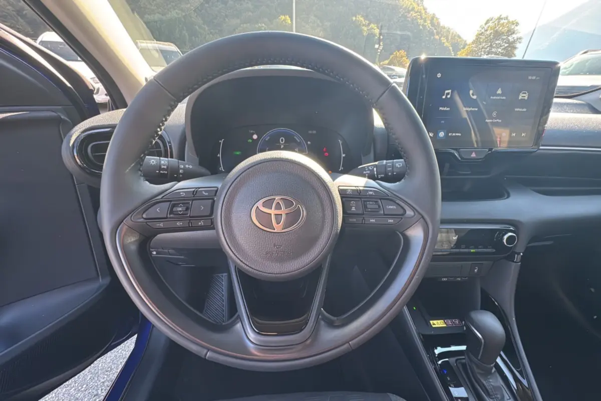 Vue centrée sur le volant et le tableau de bord de la Toyota Yaris 1.5 Hybrid 116 BVA Design 2025, intérieur noir.