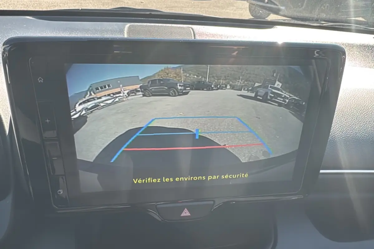 Écran de caméra de recul affichant une vue arrière dégagée avec lignes de guidage colorées dans une Toyota Yaris 2025 bleu genievre.
