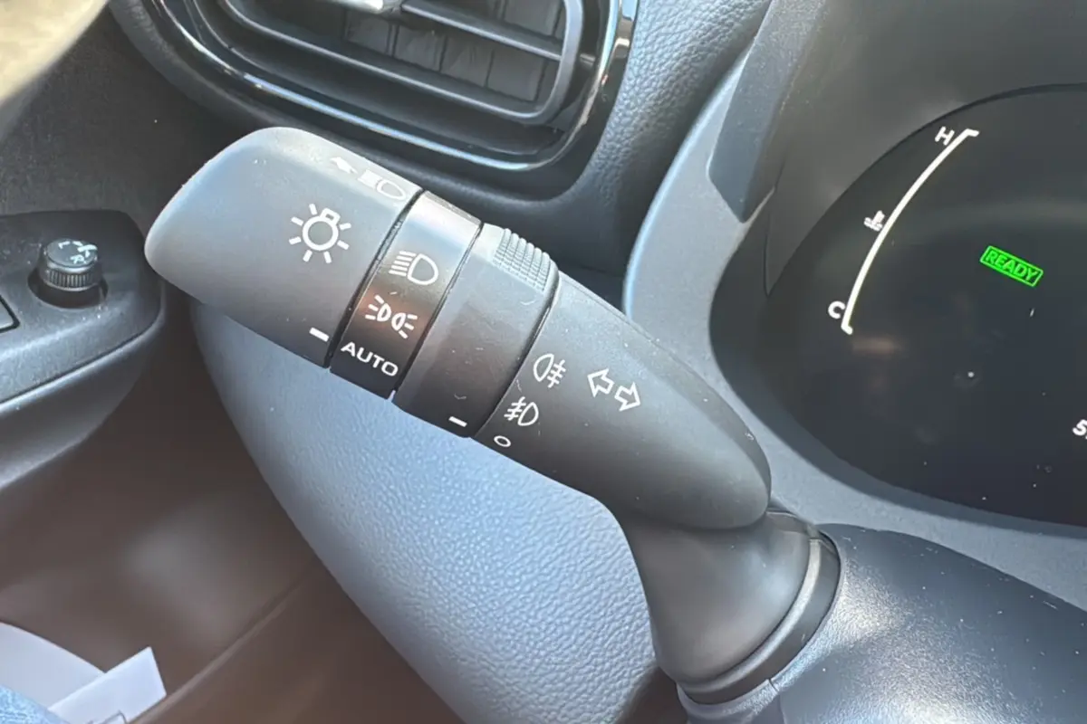 Gros plan sur la commande des feux et clignotants à gauche du volant d'une Toyota Yaris 1.5 Hybrid 2025.