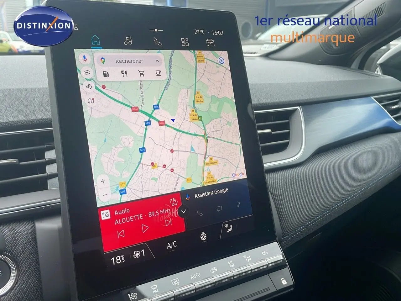Vue intérieure centrée sur l'écran tactile du tableau de bord du Renault Captur blanc nacré toit noir, affichant la navigation GPS.