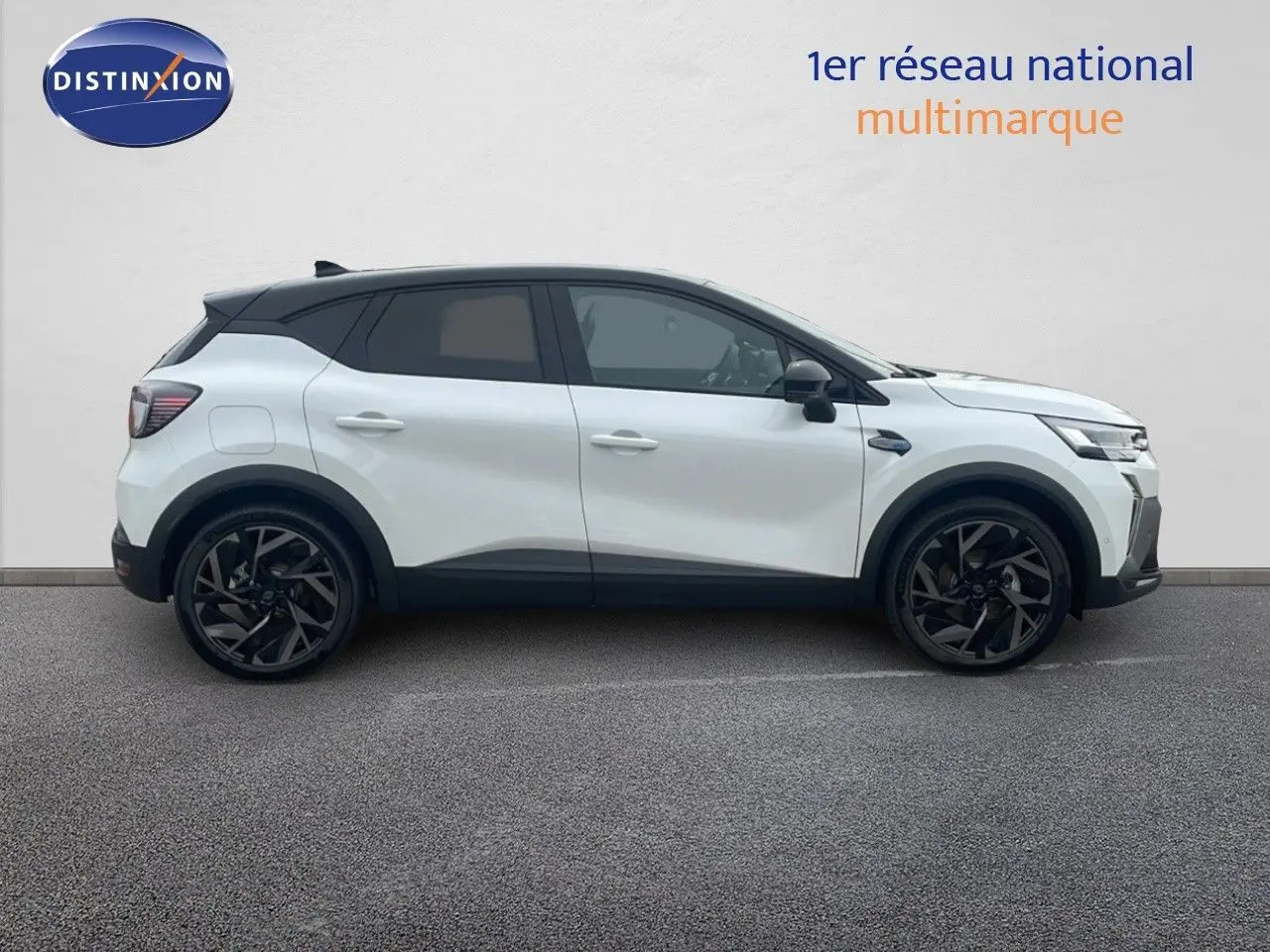 Profil latéral droit du Renault Captur E-Tech hybride blanc nacré avec toit noir, jantes noires et lignes modernes.