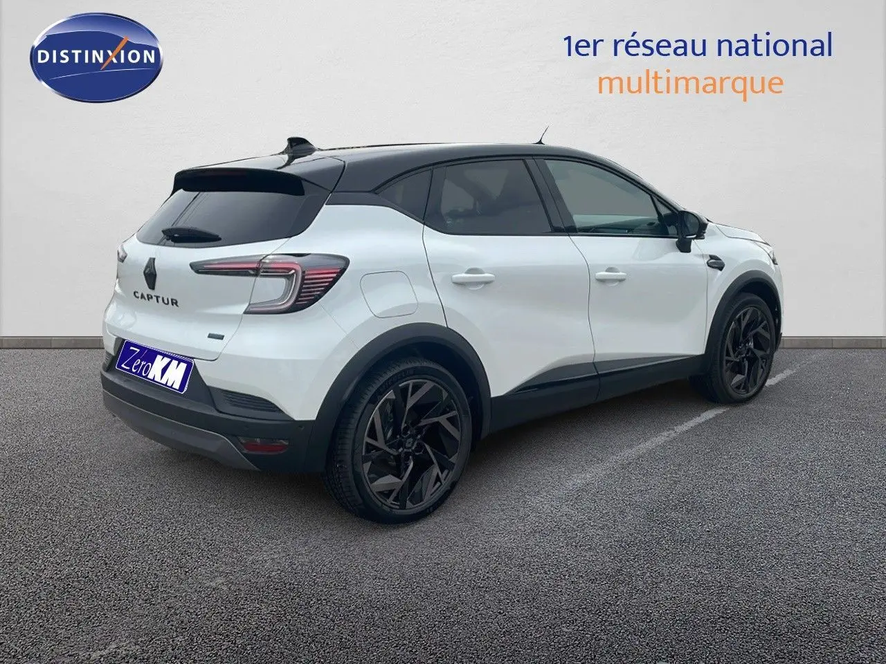 Renault Captur E-Tech hybride blanc nacré avec toit noir, vue 3/4 arrière côté gauche, jantes noires distinctives.