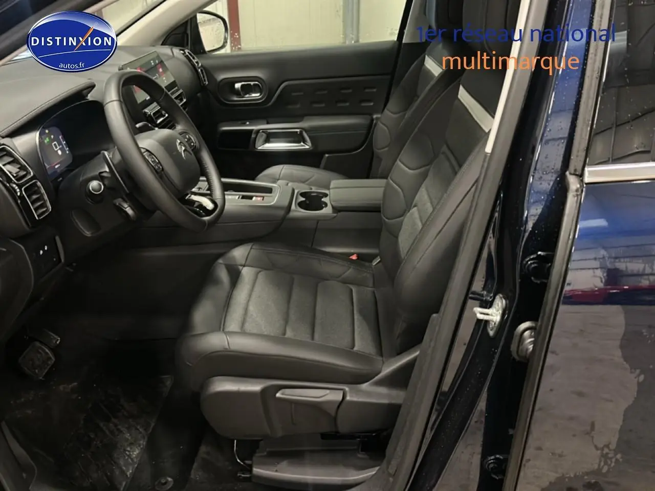 Vue intérieure côté conducteur du Citroën C5 Aircross bleu eclipse, montrant sièges cuir noirs et tableau de bord moderne.