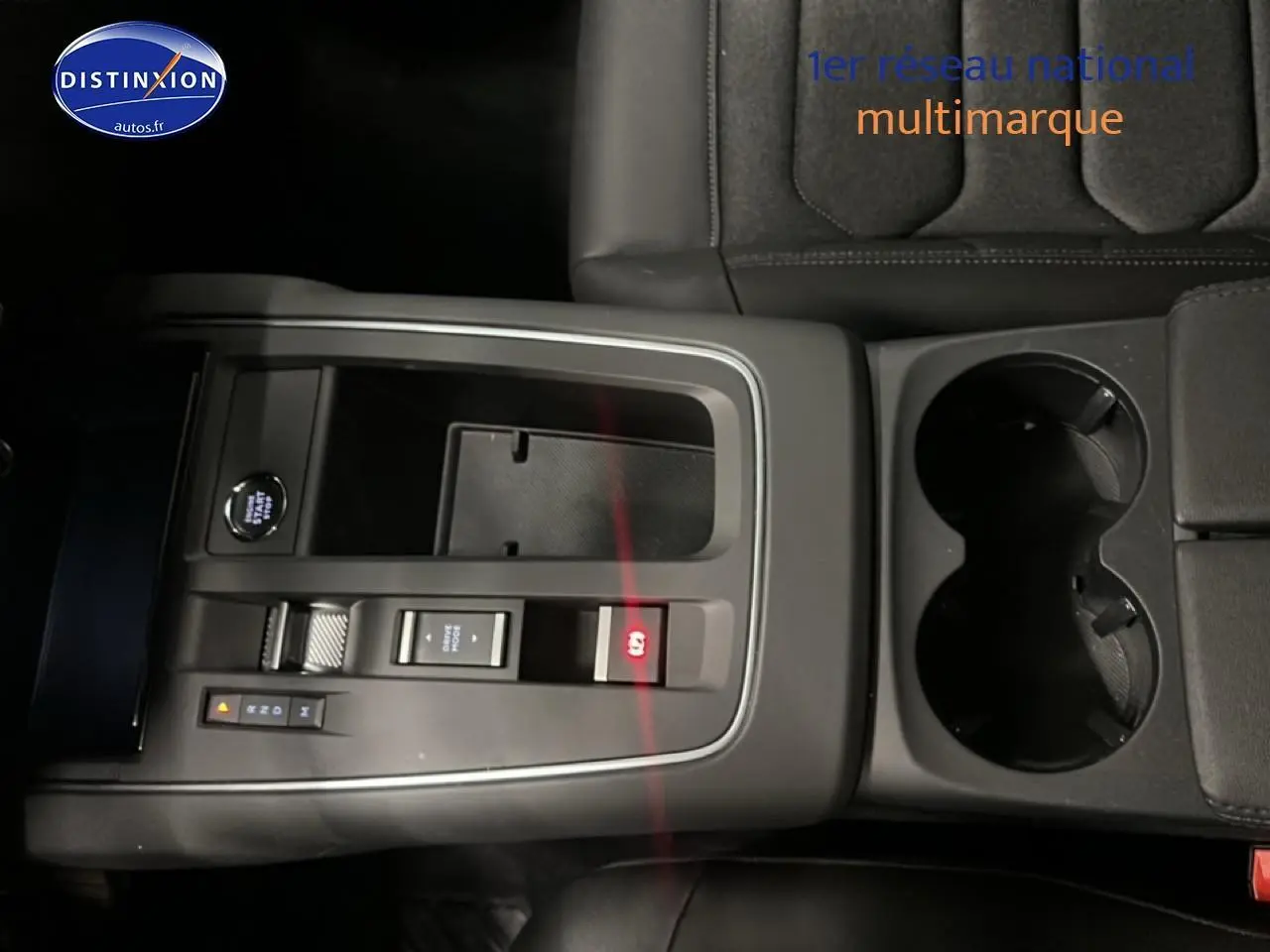 Vue rapprochée de la console centrale noire du Citroën C5 Aircross 2025 avec commandes et porte-gobelets.
