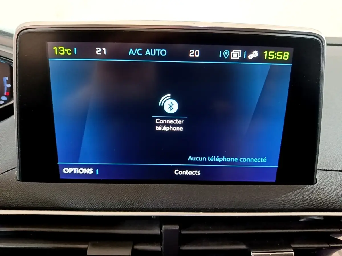 Écran tactile central du tableau de bord du Peugeot 3008 blanc, affichant la connexion Bluetooth téléphone.