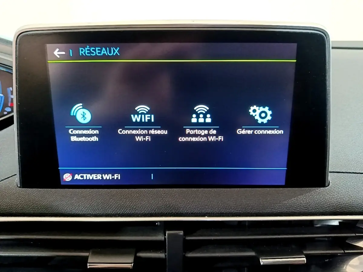 Écran tactile central du tableau de bord du Peugeot 3008 blanc, affichant les options de connexion Wi-Fi et Bluetooth.