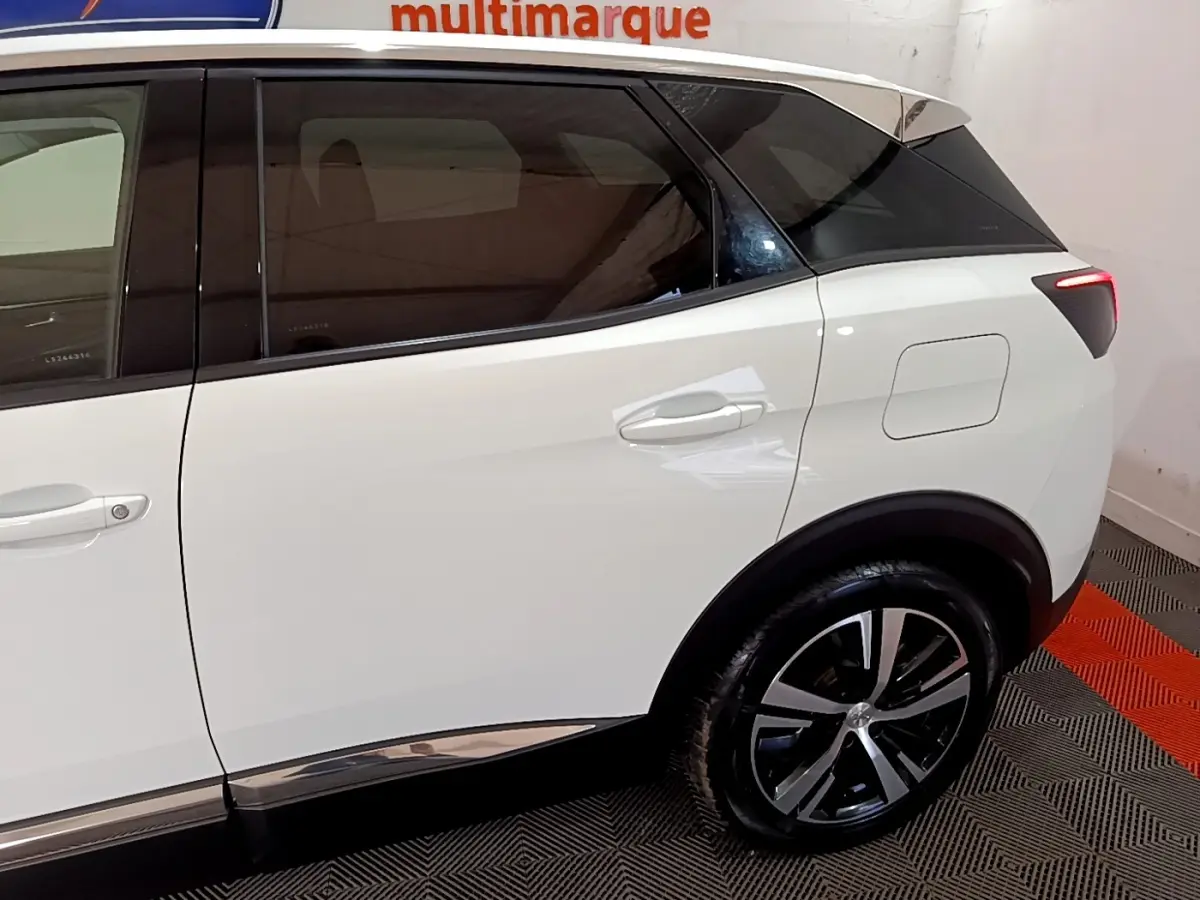 Vue latérale droite du Peugeot 3008 blanc hybride rechargeable, mettant en valeur la roue arrière et la trappe de recharge.