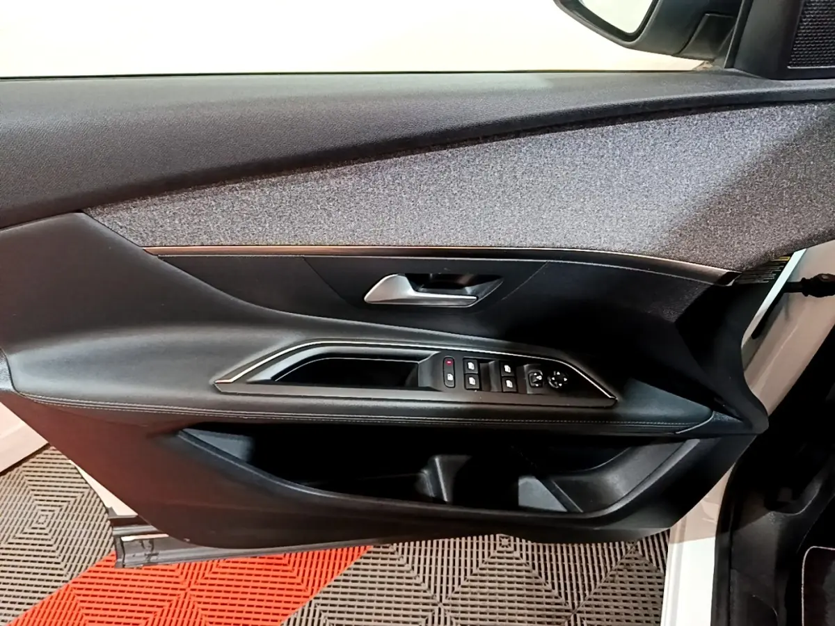 Vue intérieure du panneau de porte avant gauche noir avec commandes électriques sur Peugeot 3008 blanc hybride rechargeable 2020.