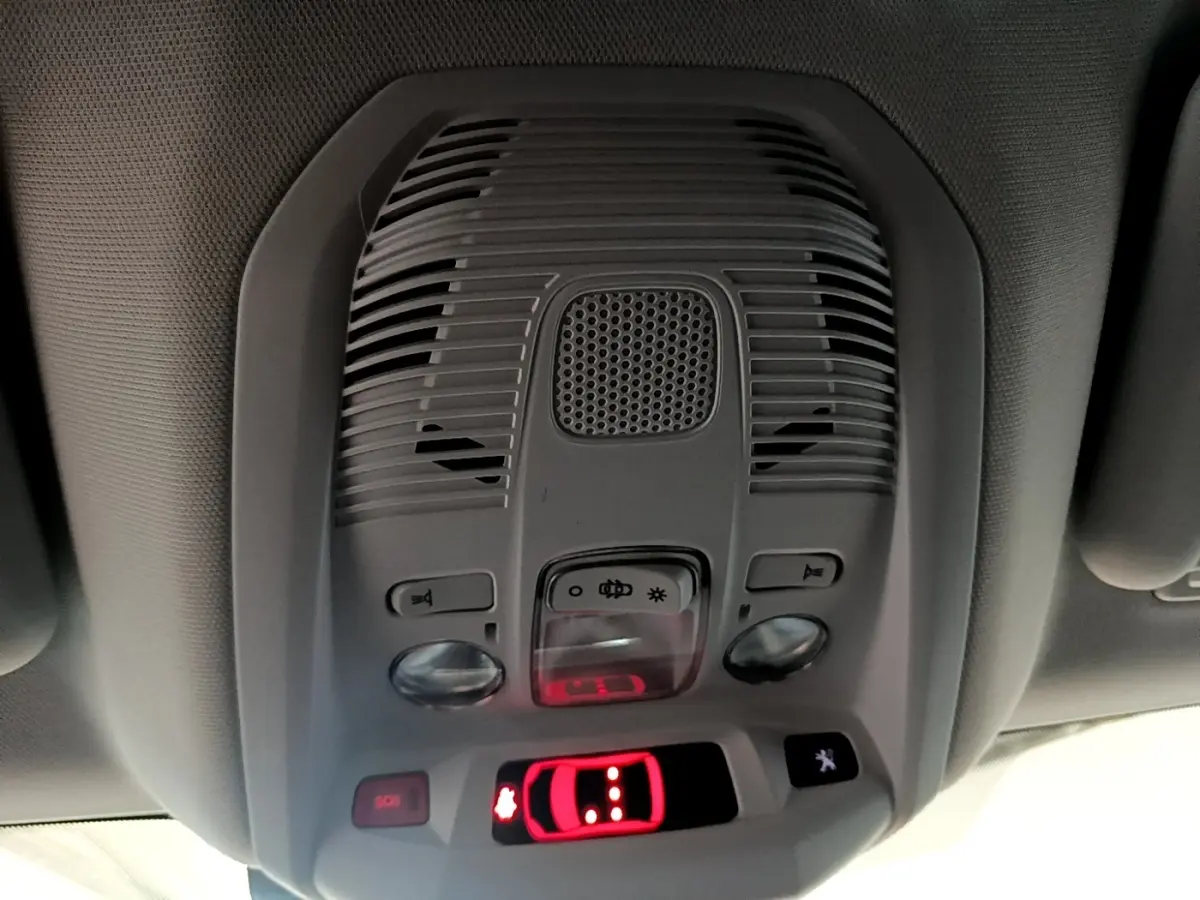 Vue intérieure du plafonnier gris avec commandes d’éclairage et indicateur de porte ouverte rouge du Peugeot 3008 blanc hybride.