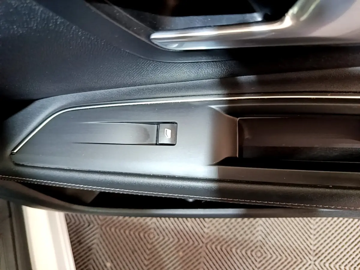 Détail de la commande de lève-vitre côté gauche intérieur du Peugeot 3008 blanc hybride rechargeable.