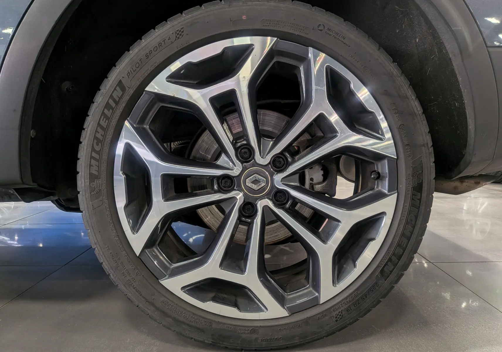 Gros plan sur la roue avant droite du Renault Kadjar gris Titanium avec jante alliage à design moderne et logo central Renault.