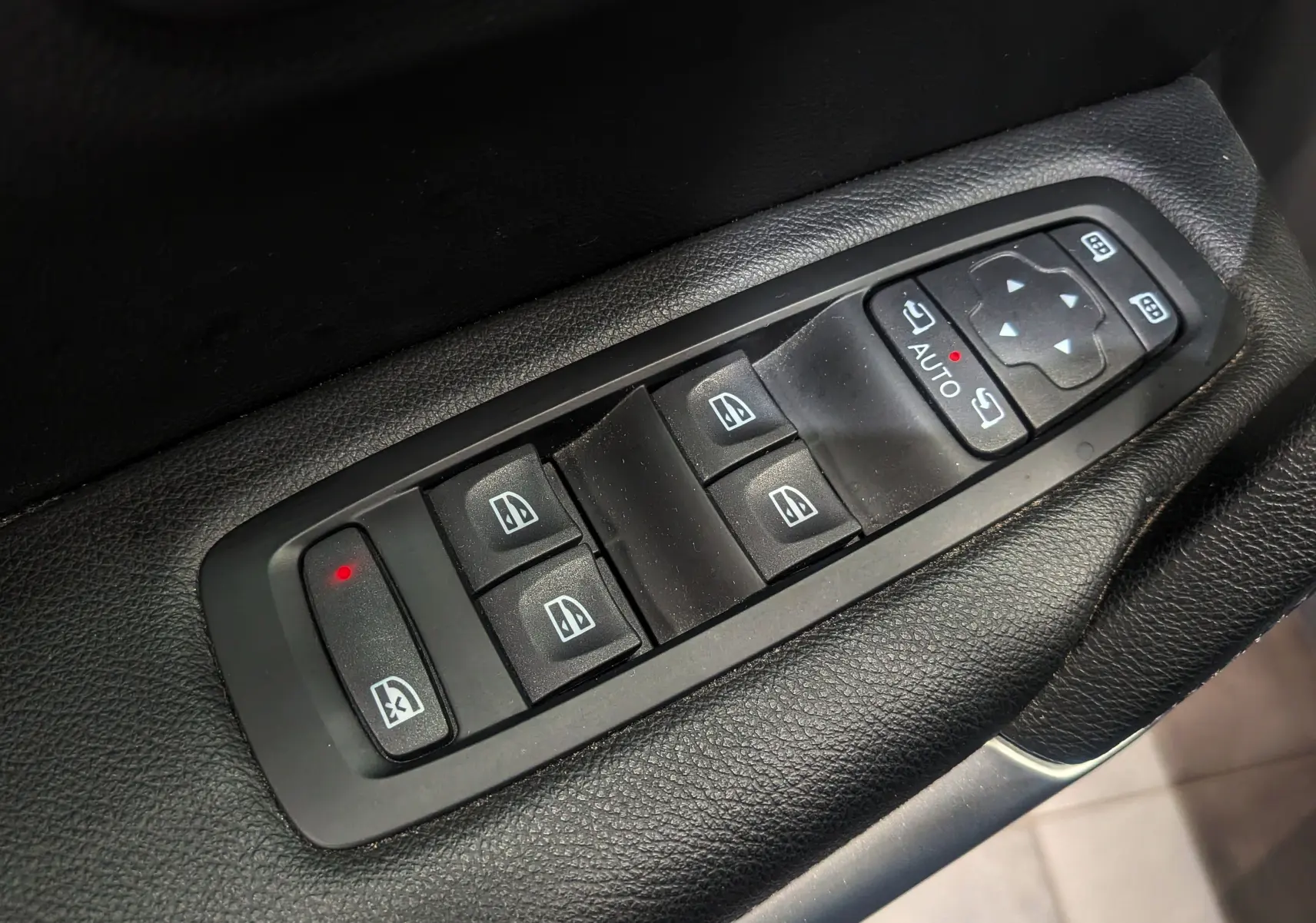 Gros plan sur les commandes de lève-vitres et rétroviseurs électriques du côté conducteur du Renault Kadjar TCe 140 Gris Titanium.