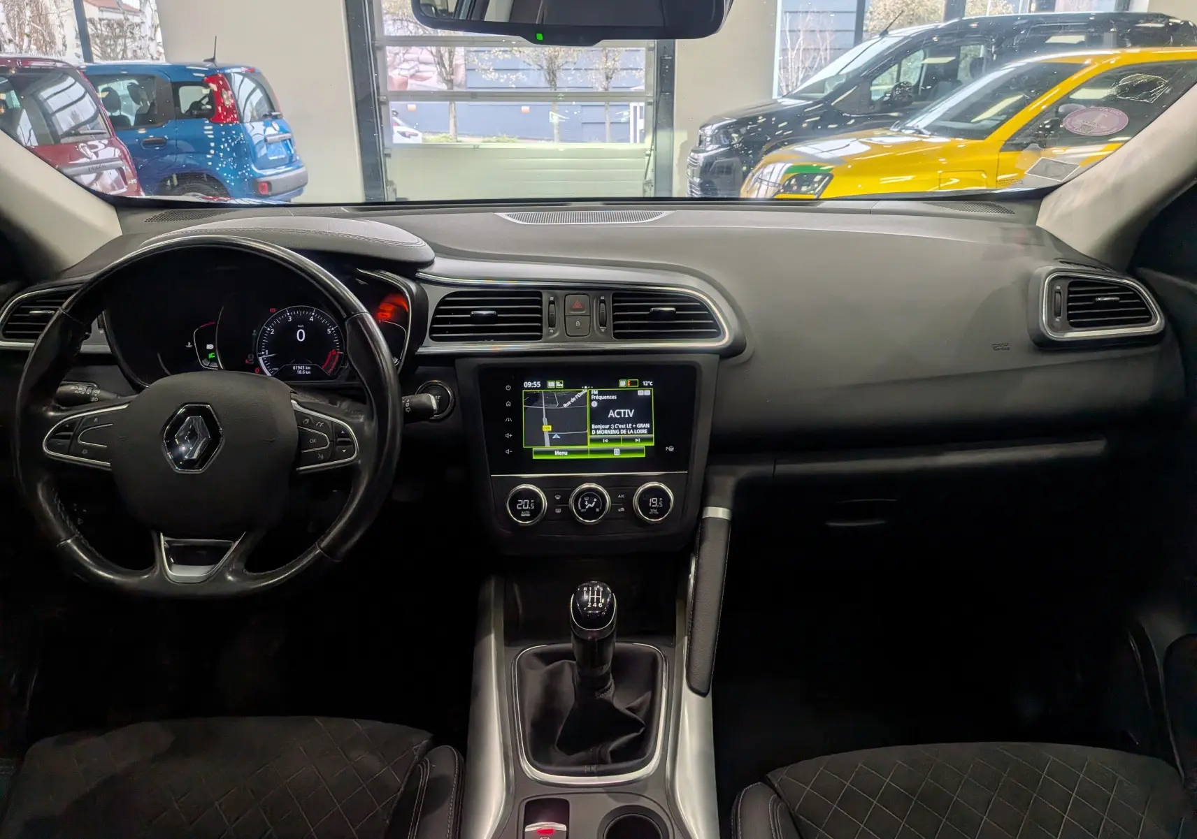 Vue intérieure avant du Renault Kadjar TCe 140 Intens 2019, tableau de bord noir avec écran tactile et levier de vitesses manuel.