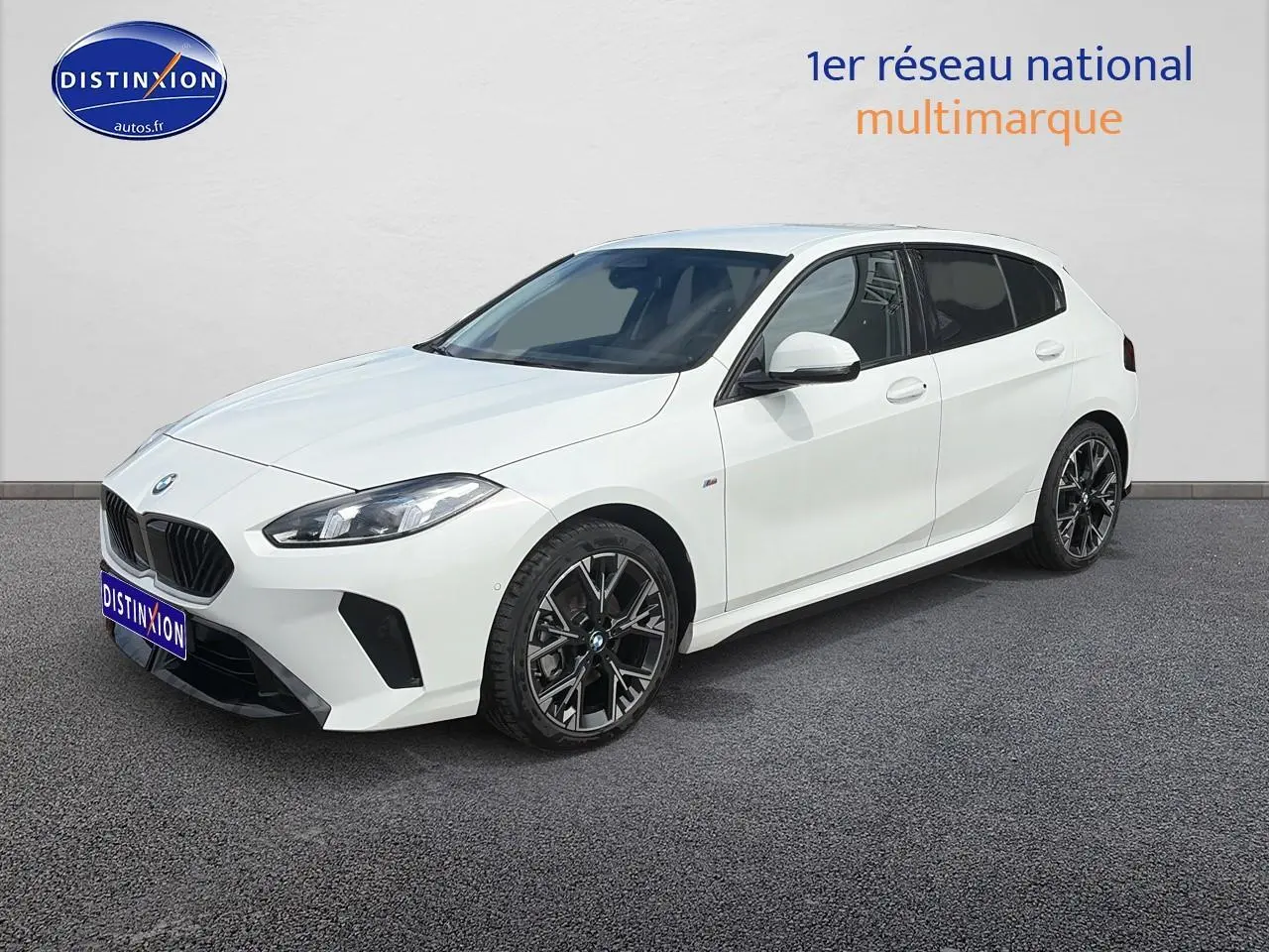 BMW Série 1 blanche vue en 3/4 avant droit avec jantes noires et calandre caractéristique M Sport.