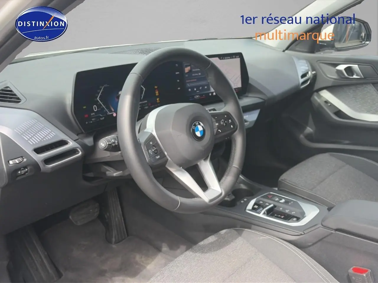 Vue intérieure côté conducteur de la BMW Série 1 120da 2025, volant cuir et tableau de bord numérique.