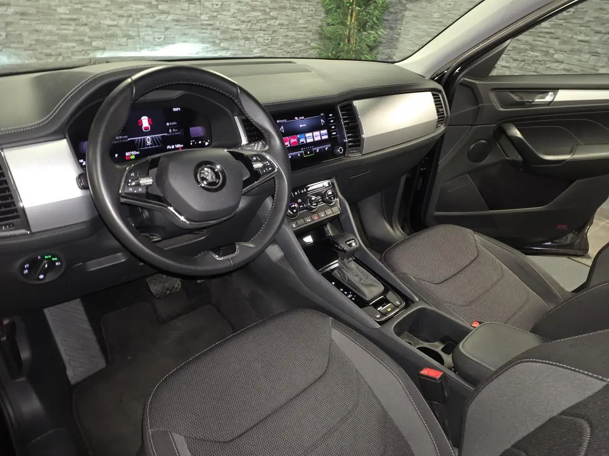Intérieur noir du Skoda Kodiaq 2023 vu côté conducteur, avec tableau de bord digital et console centrale moderne.