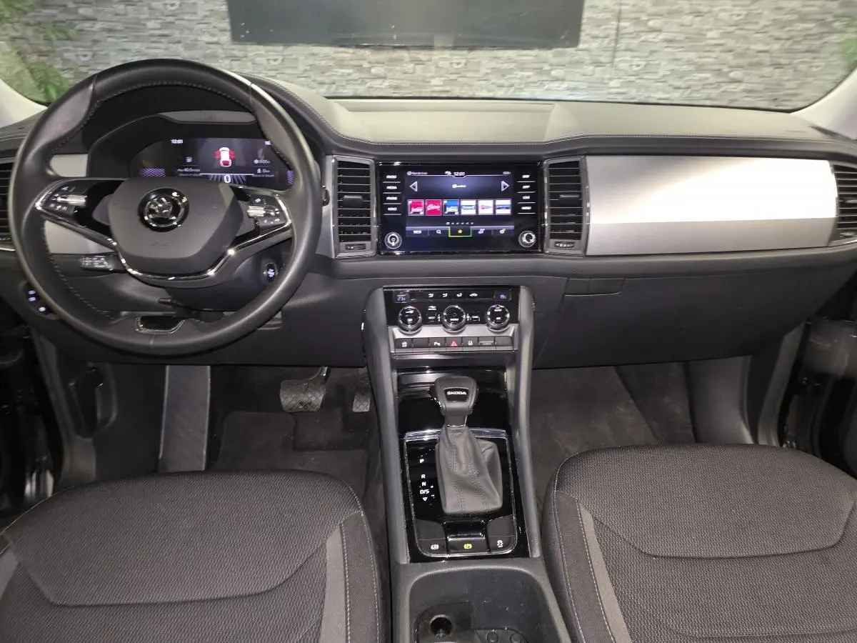 Vue intérieure avant du Skoda Kodiaq noir 2023, tableau de bord moderne avec écran tactile et levier de vitesses automatique.