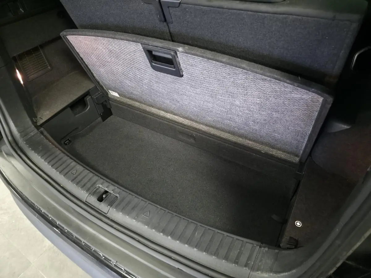 Coffre ouvert vu de dessus d’un Skoda Kodiaq noir 2023 avec compartiment de rangement sous plancher.