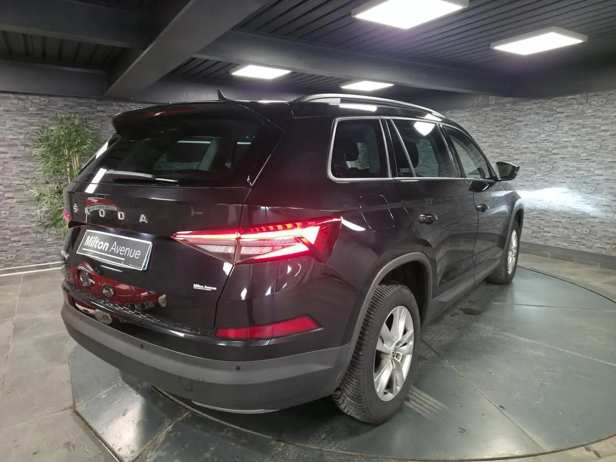 Vue 3/4 arrière droite du Skoda Kodiaq noir 2023 avec feux arrière LED allumés dans un garage.