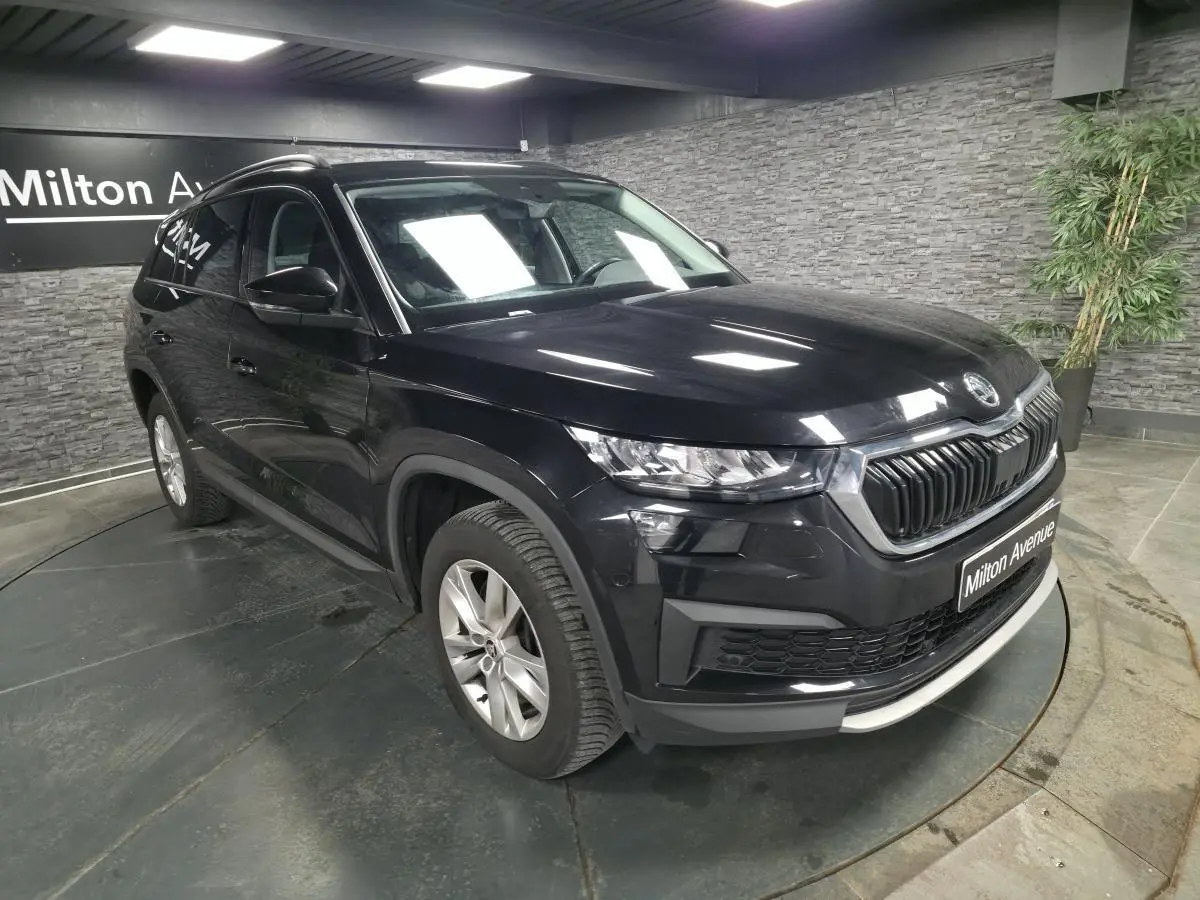 Vue 3/4 avant gauche d'un SUV Skoda Kodiaq noir métallisé avec calandre chromée et jantes alliage 17 pouces.