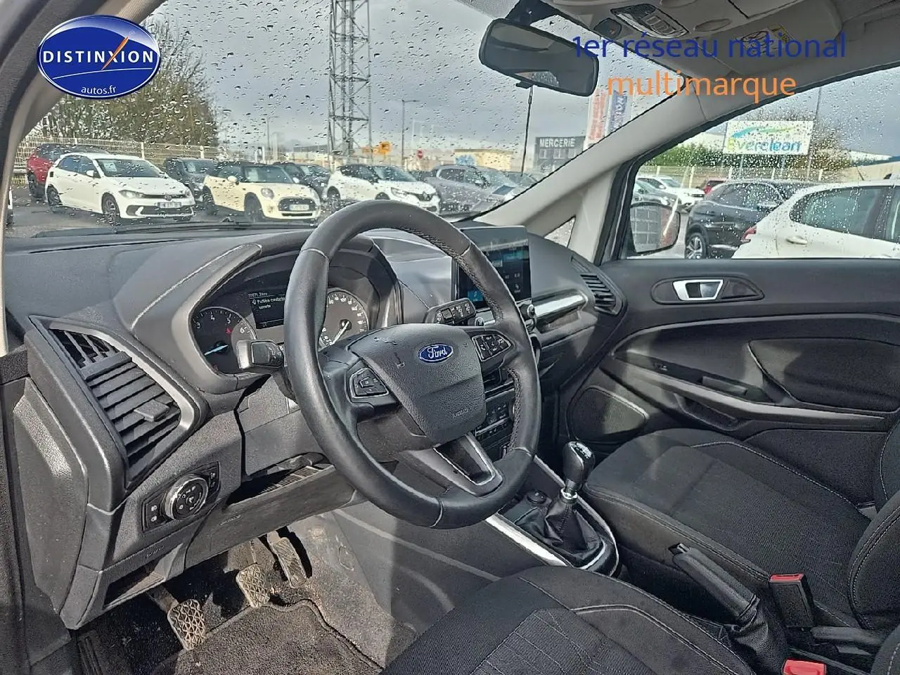 Intérieur avant droit du Ford EcoSport 2019 avec volant cuir, tableau de bord noir et levier de vitesses manuel.
