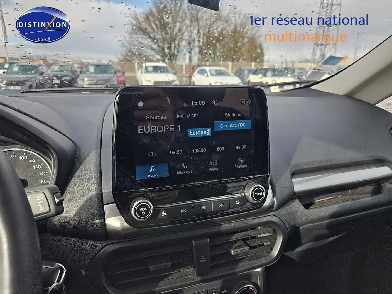 Vue intérieure centrée sur l’écran tactile du tableau de bord d’un Ford Ecosport gris, avec volant partiel visible à gauche.