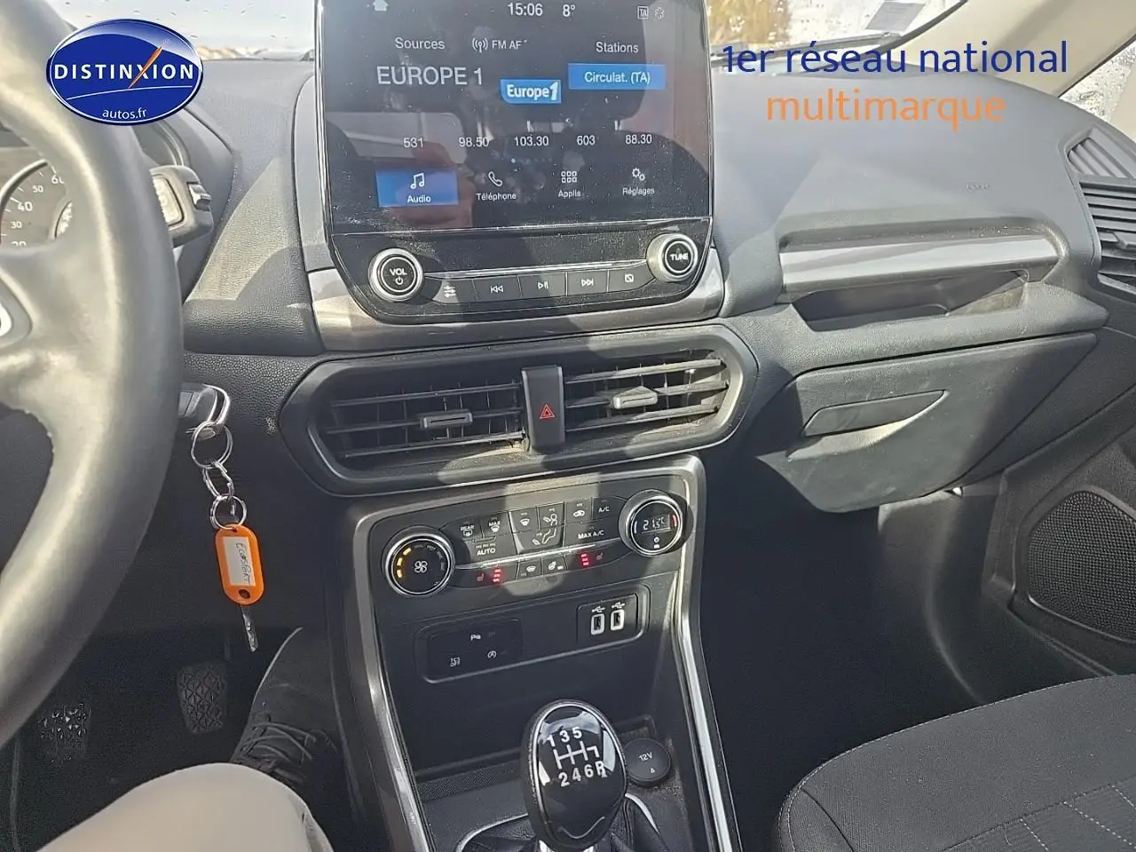 Vue intérieure avant du Ford EcoSport gris 2019, mettant en valeur la console centrale avec écran tactile et levier de vitesse manuel.
