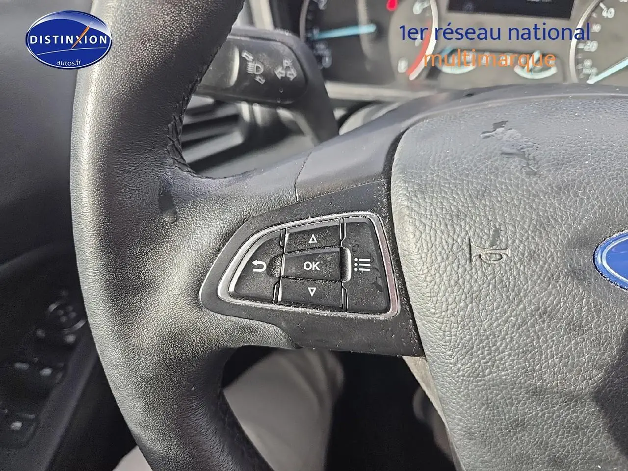 Gros plan sur le volant en cuir noir du Ford Ecosport 2019, montrant les commandes multifonctions côté gauche.