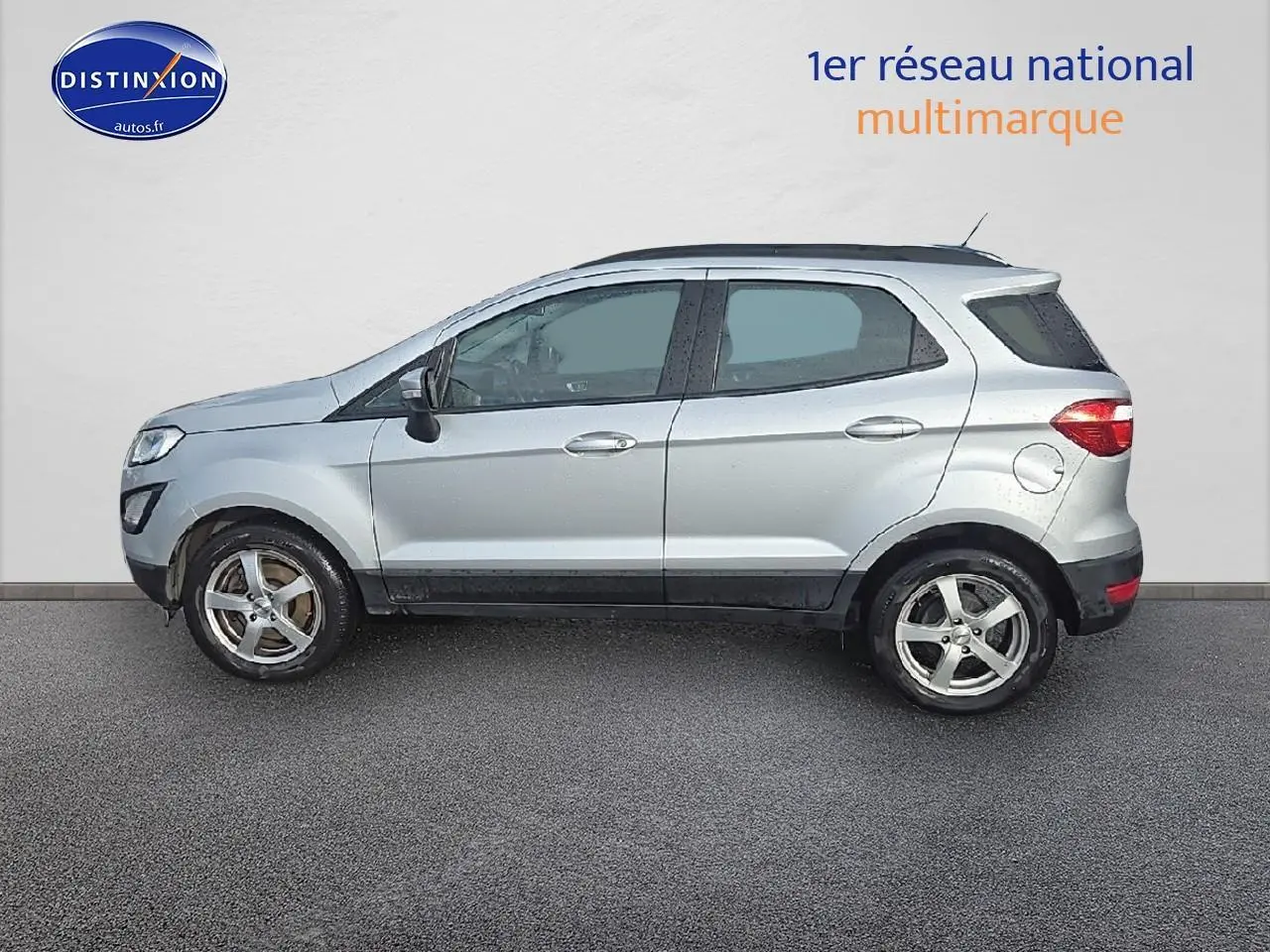 Vue de profil côté gauche d'un Ford EcoSport gris 2019 avec jantes alliage et barres de toit noires.
