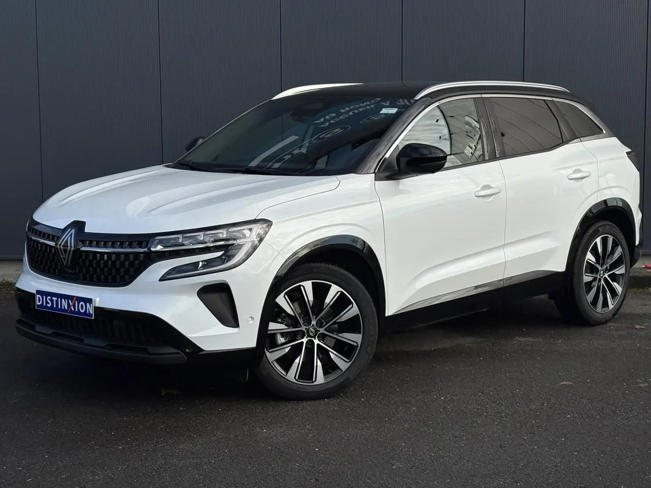 Renault Austral blanc nacré en 3/4 avant droit, toit panoramique noir étoilé et jantes alliage noires diamantées.