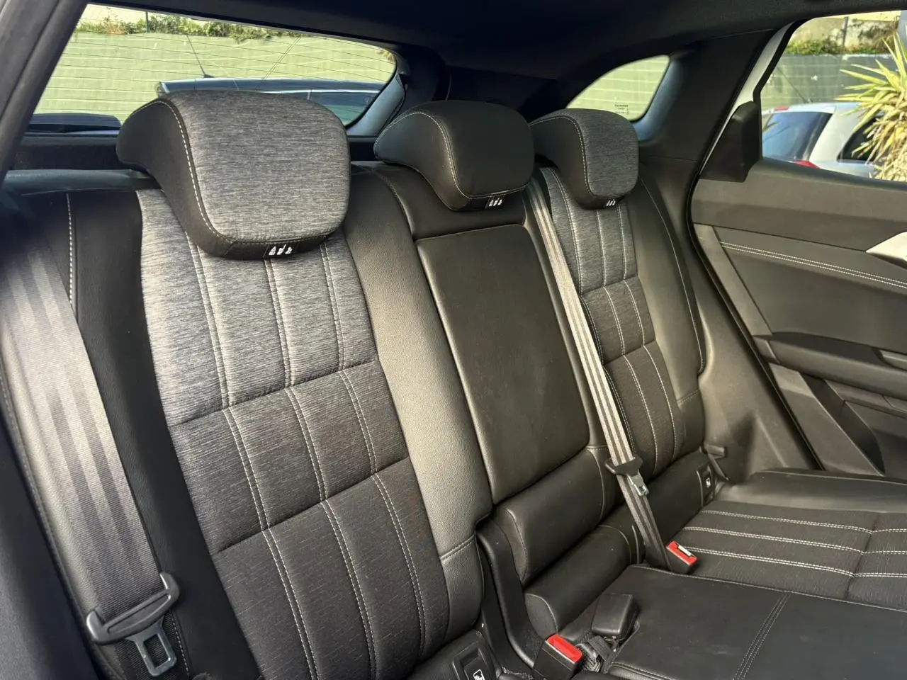 Vue intérieure de la banquette arrière en sellerie mixte gris et noir du Renault Austral 2025.