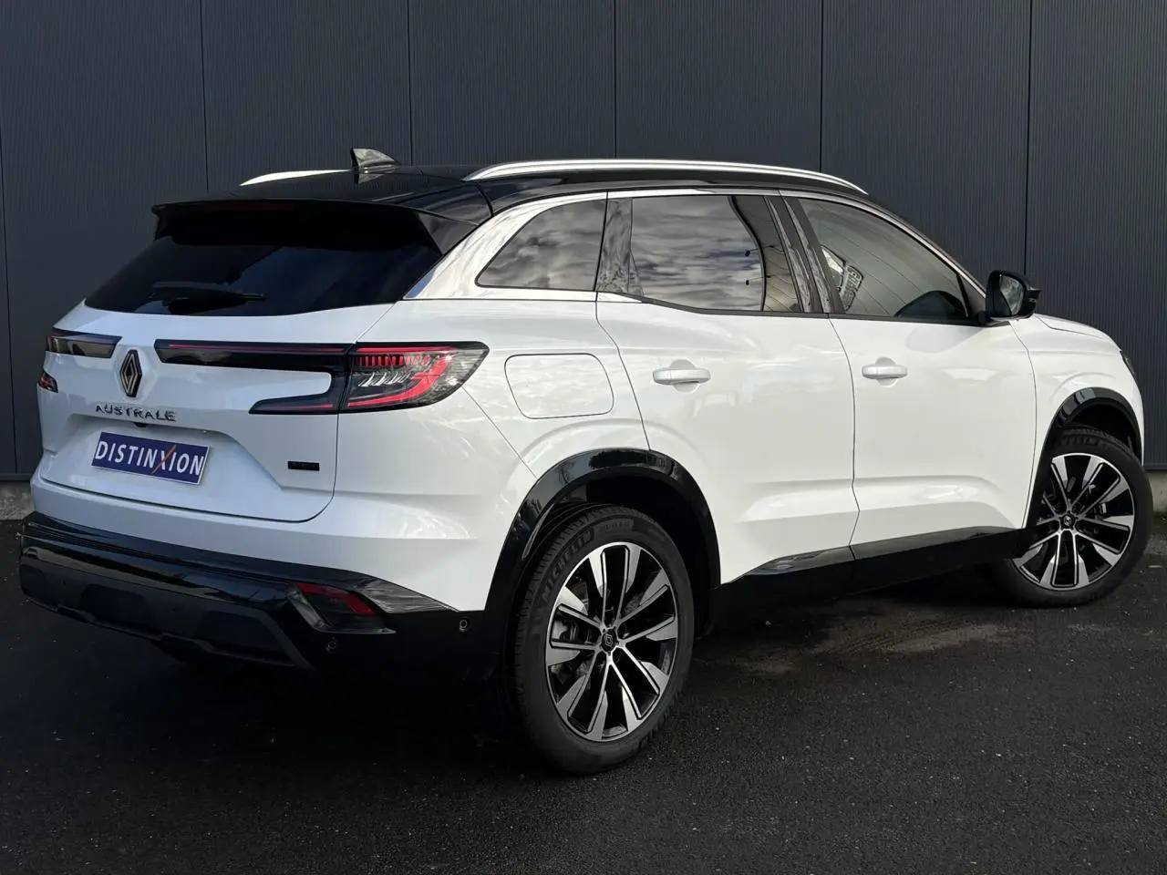 Vue 3/4 arrière droite du Renault Austral blanc nacré avec toit noir étoilé et jantes alliage noires diamantées.