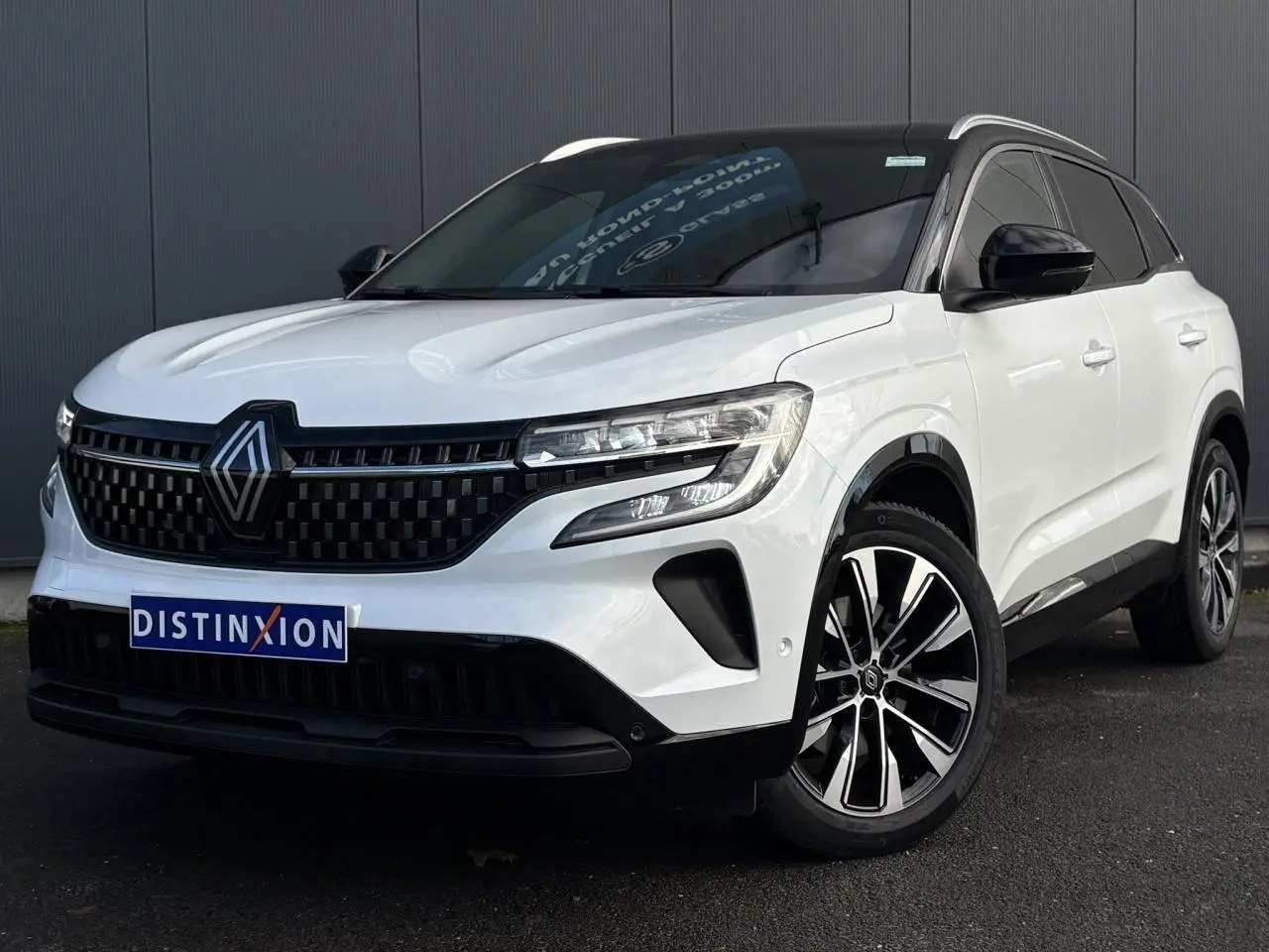 Renault Austral blanc nacré en 3/4 avant droit avec toit noir étoilé et jantes alliage noires diamantées.