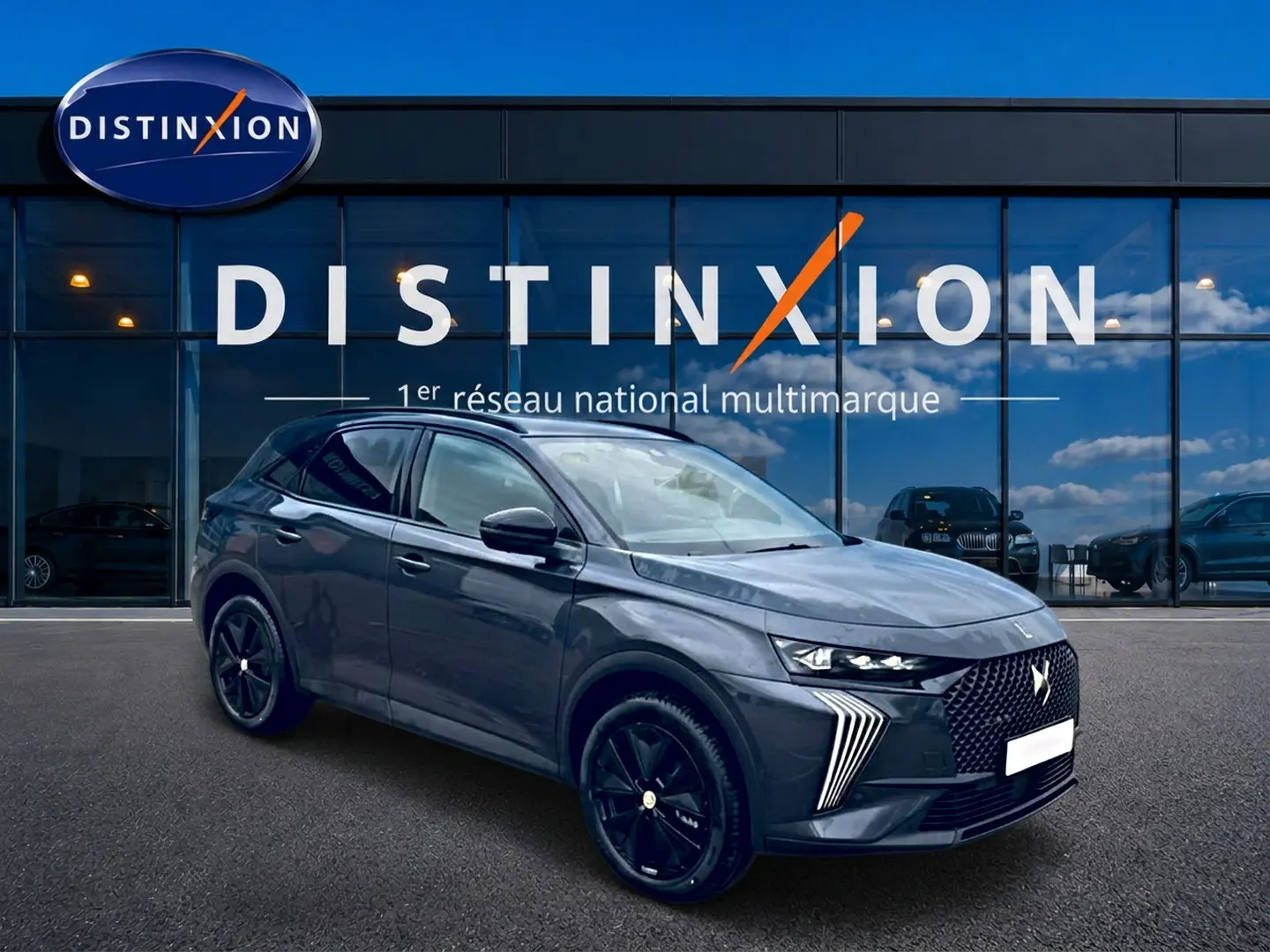 DS7 1.5 BlueHDi gris titane en 3/4 avant droit, avec calandre distinctive et jantes noires brillantes.