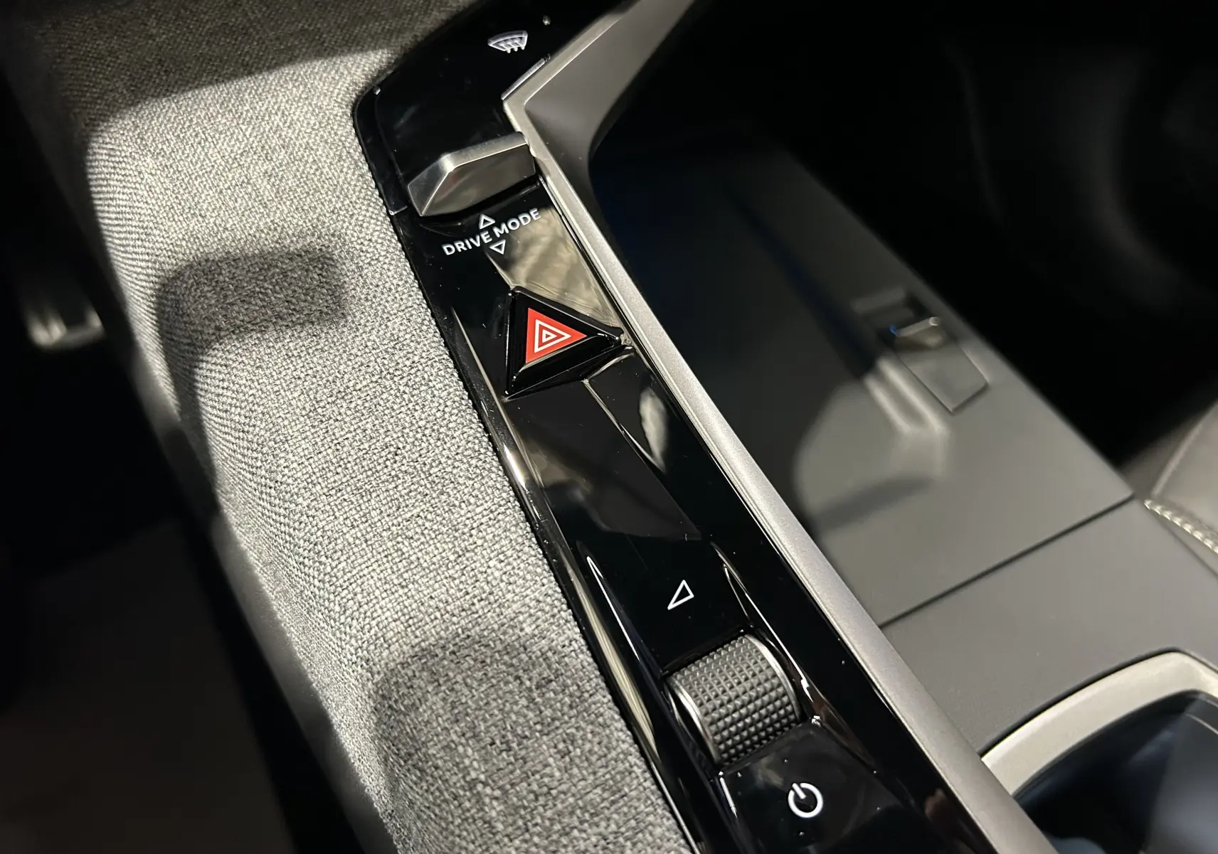 Gros plan sur la console centrale intérieure du Peugeot 3008 III Hybrid avec bouton de mode de conduite et signal d’alerte.