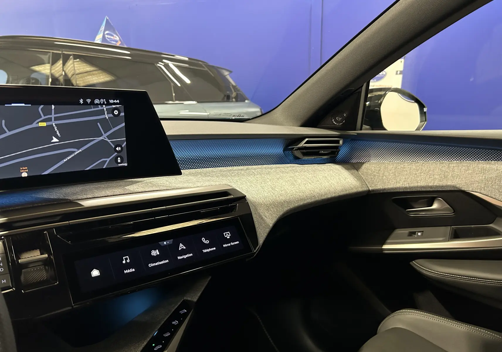 Vue intérieure côté passager du Peugeot 3008 III Hybrid 145 GT, avec tableau de bord moderne et éclairage bleu Obsession.