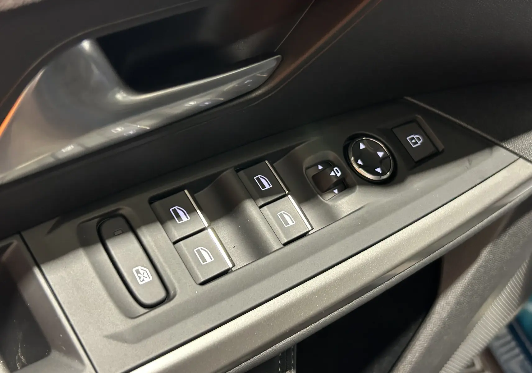 Gros plan sur les commandes de lève-vitres et rétroviseurs côté conducteur du Peugeot 3008 III Hybrid bleu Obsession.