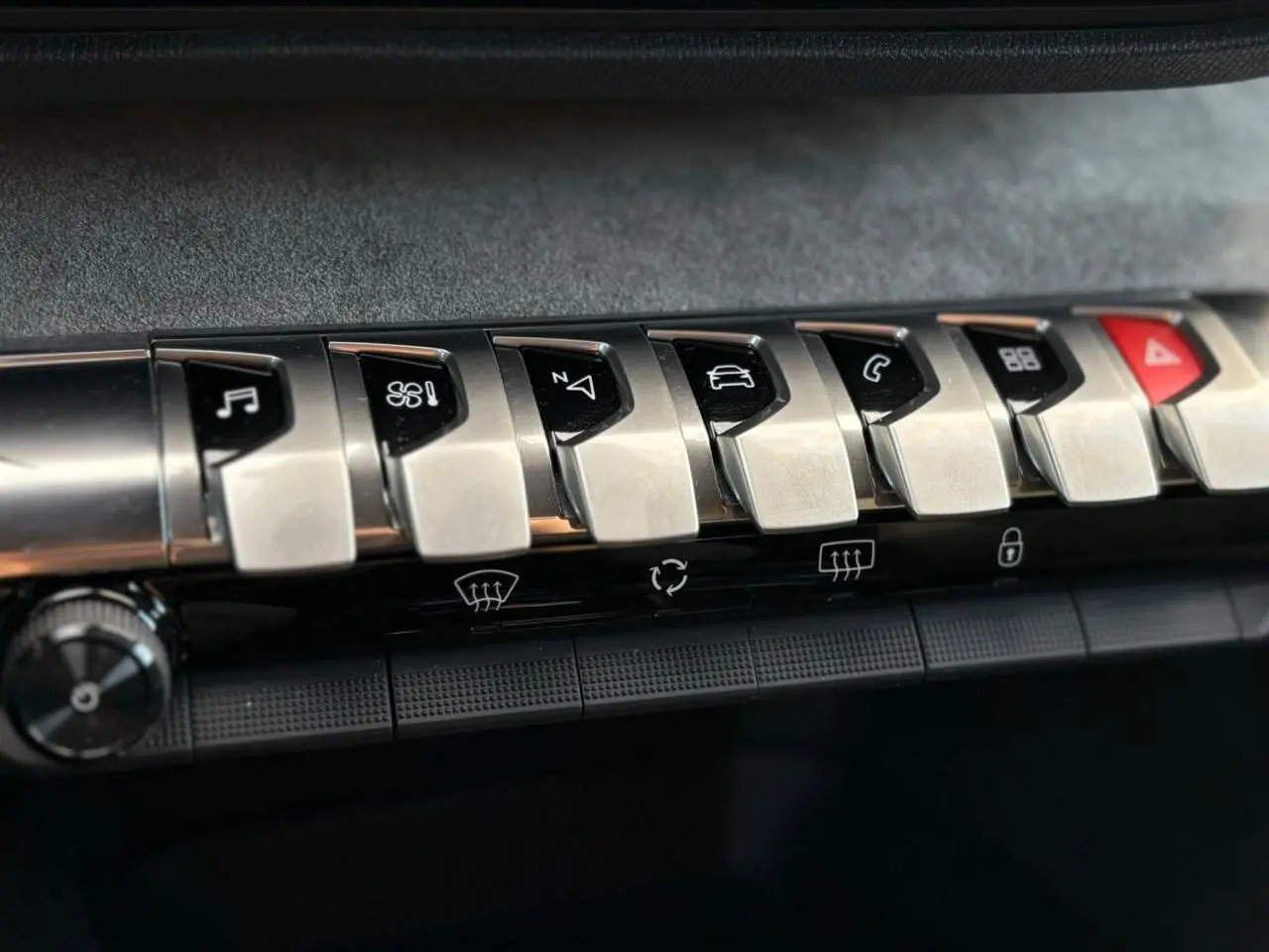 Gros plan sur les boutons chromés du tableau de bord du Peugeot 3008 GT 2023, soulignant les commandes multimédia et climatisation.