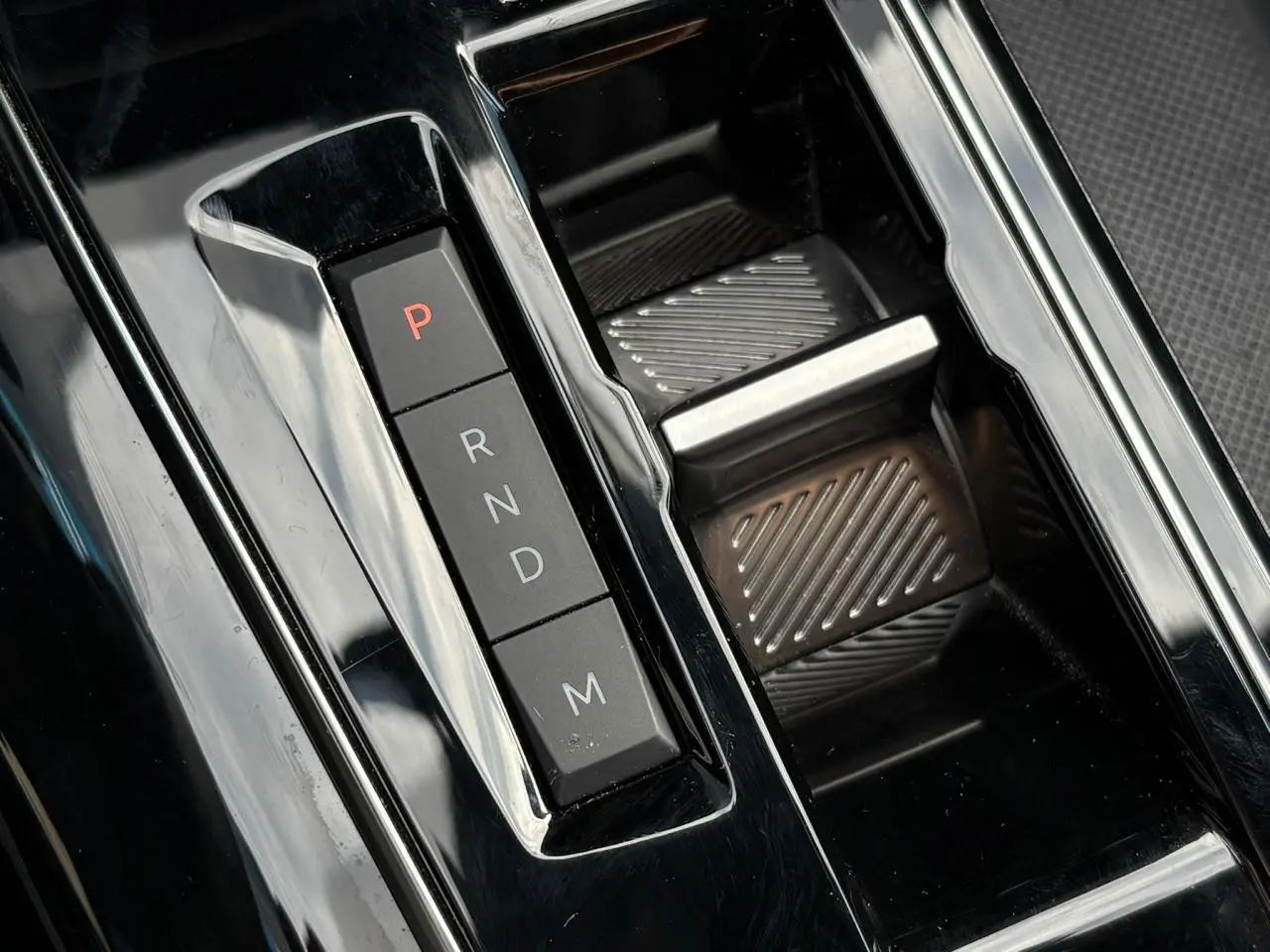 Gros plan sur la commande de boîte automatique noire brillante du Peugeot 3008 2023 avec sélecteur électronique P-R-N-D-M.