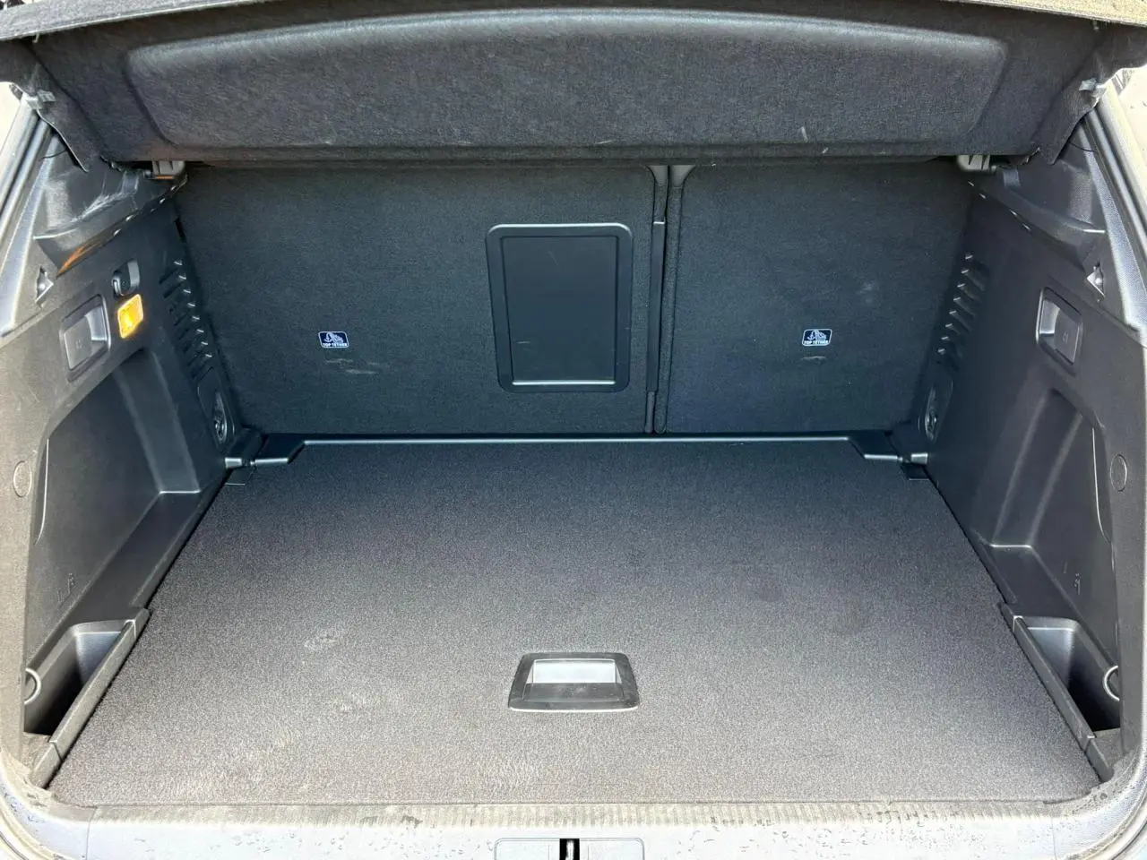 Coffre spacieux et propre du Peugeot 3008 GT 2023 avec banquette rabattable et compartiments latéraux visibles.