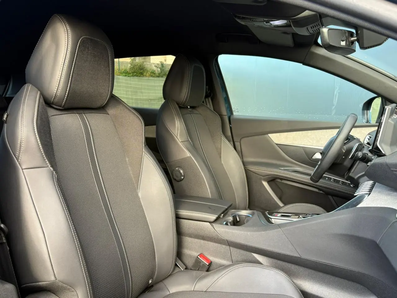 Vue intérieure côté droit du Peugeot 3008 GT 2023 montrant les sièges Mi-TEP/tissu Belomka gris et l'accoudoir central fermé.