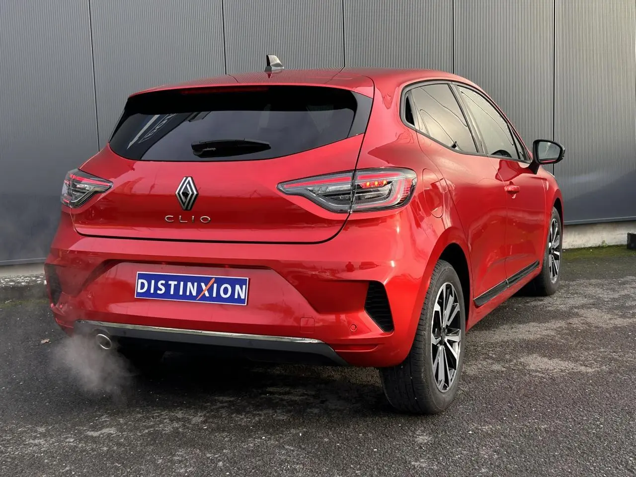Vue 3/4 arrière droite d'une Renault Clio Rouge Désir avec feux LED et jantes alliage diamantées.