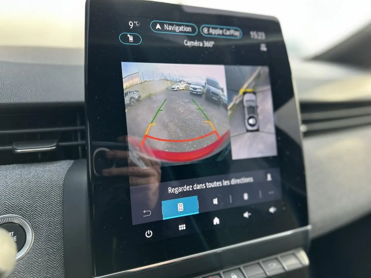 Écran tactile intérieur de la Renault Clio Rouge Désir montrant la caméra 360° en mode recul avec guidage.