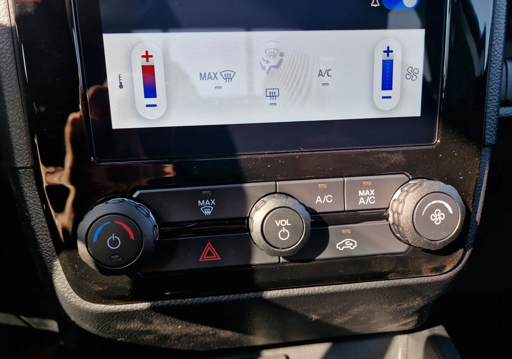 Gros plan sur la console centrale du Ford Ranger Super Cabine 2026, montrant les commandes climatisation et volume.