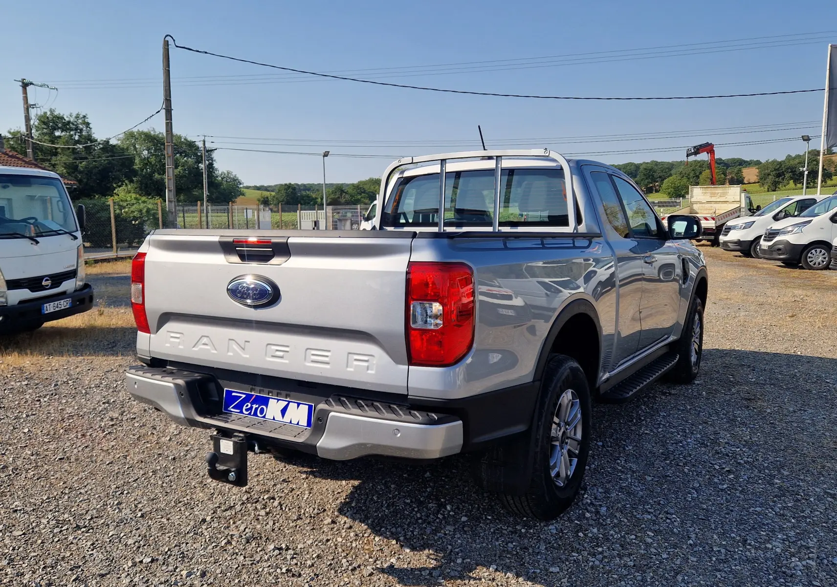 Vue 3/4 arrière droite du Ford Ranger Super Cabine gris Iconic avec attelage et barres de protection sur la benne.