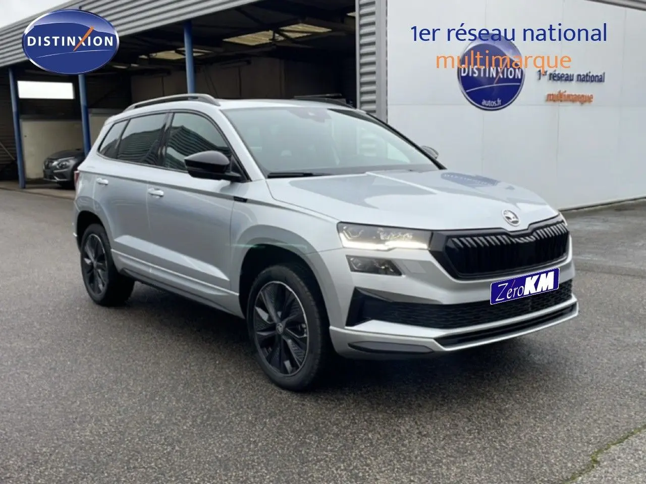Vue 3/4 avant d'un Skoda Karoq gris argent métallisé avec jantes noires et calandre noire distinctive.