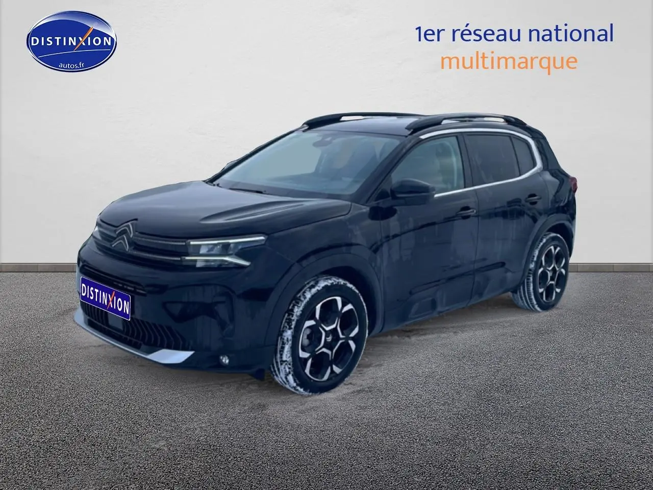 Citroën C5 Aircross noir vue 3/4 avant droit avec jantes alu et barres de toit visibles.