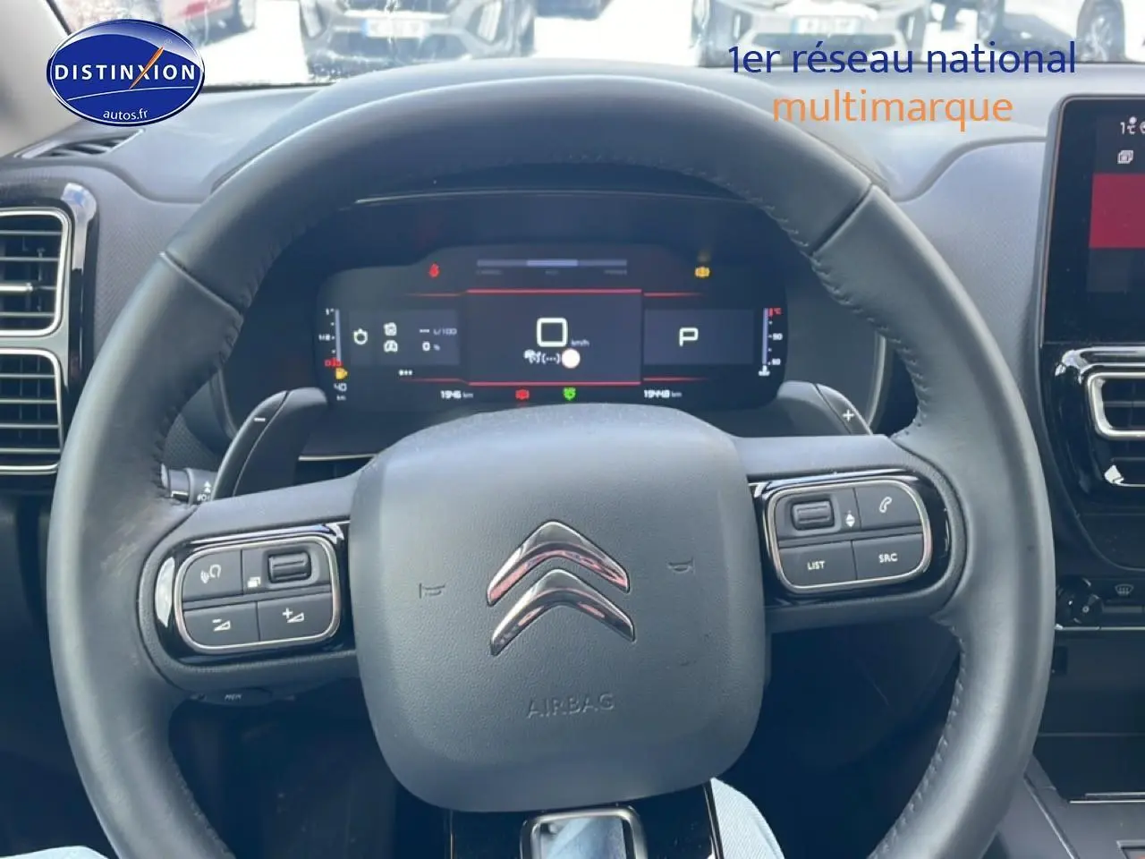 Vue rapprochée du volant cuir noir multifonction du Citroën C5 Aircross 2025 avec tableau de bord digital.