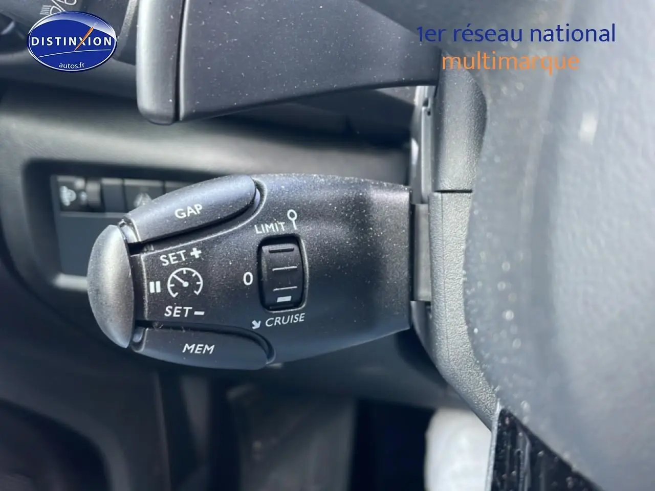 Gros plan sur la commande de régulateur de vitesse au volant d'une Citroën C5 Aircross noire, intérieur visible.